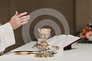 Unrecognizable Priest holding the goblet during a wedding ceremony nuptial mass. Religion concept photo