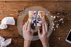 Unrecognizable sad woman holding torn picture of couple in love.