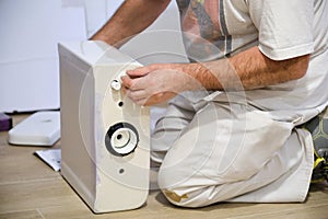 Unrecognizable senior plumber installer installing toilet cistern.