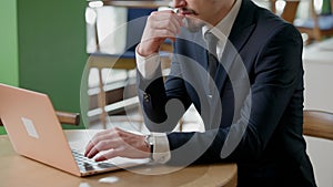 Unrecognizable serious CEO businessman messaging online sitting in cafe or restaurant. Thoughtful concentrated Caucasian