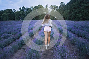 Unrecognizable slim woman running in lavender field.