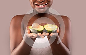 Unrecognizable Smiling Black Lady Wrapped In Towel Holding Avocado Halves