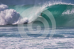 Unrecognizable surfer encapsulated in the center of a wave.         ave