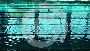 Unrecognizable swimmer silhouette in The Pool With Blue Water And Dividers Of Swimming Tracks