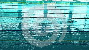 Unrecognizable swimmer silhouette in The Pool With Blue Water And Dividers Of Swimming Tracks