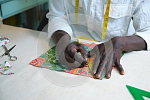 Unrecognizable tailor measuring fabric using a measure tape.