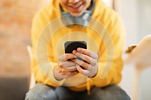 Unrecognizable Teen Boy Using Phone Playing Mobile Games Sitting Indoors