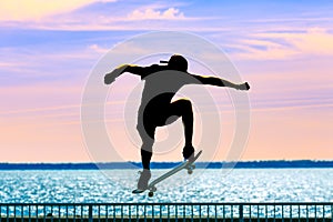 Unrecognizable teenage boy silhouette showing high jump tricks on scooter against