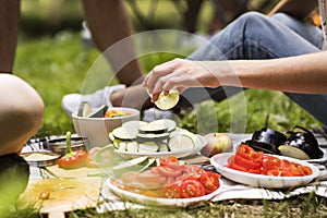 Unrecognizable teenagers camping and cooking.