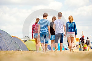 Unrecognizable teenagers, tent music festival, sunny summer, bac