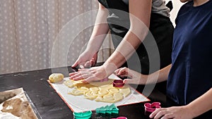 Unrecognizable woman and boy cut different shapes out of dough