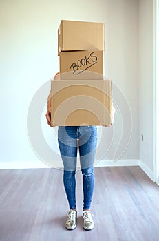 Unrecognizable woman carrying moving boxes