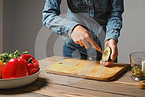 Unrecognizable woman crisscross cutting avocado