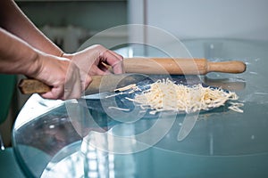 An unrecognizable woman cuts noodles. women& x27;s hands close-up