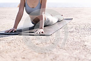 unrecognizable woman doing yoga by the sea