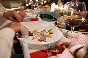 Unrecognizable woman eating Chrsitmas dinner.