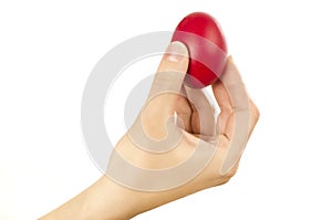 Unrecognizable woman hand holding up for egg knocking a red Easter egg.