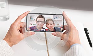 Unrecognizable woman having videocall with her sons, using mobile application