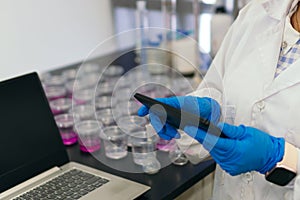 Unrecognizable woman in laboratory typing on a tablet