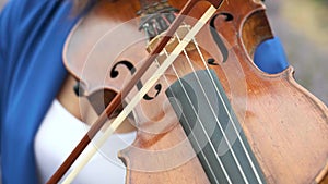 Unrecognizable woman musician playing performing violin outdoors close-up