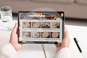 Unrecognizable Woman Ordering Lunch Online Using Digital Tablet Indoors, Cropped