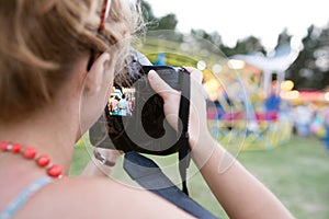 Unrecognizable woman photographing senior couple, fun fair