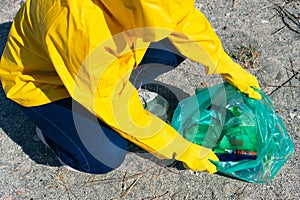 Unrecognizable woman picking up trash in the park