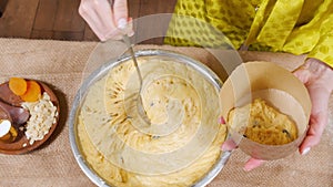 Unrecognizable woman preparing delicious Easter cakes putting dough in a mold in the kitchen. Preparing for the Easter