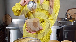 Unrecognizable woman preparing delicious Easter cakes putting dough in a mold in the kitchen. Preparing for the Easter