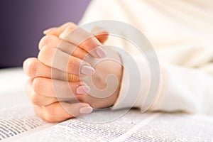 Unrecognizable woman reading big book - Holy Bible and praying. Christian studying scripture. Student in the college