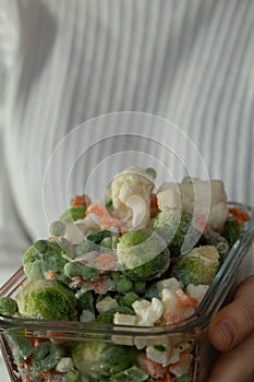 Unrecognizable woman showing Frozen mixed vegetables homemade. Harvesting concept. Stocking up vegetables for winter