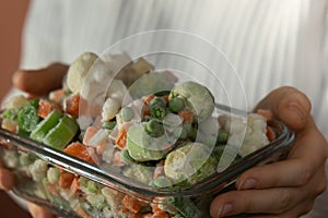 Unrecognizable woman showing Frozen mixed vegetables homemade. Harvesting concept. Stocking up vegetables for winter