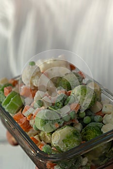 Unrecognizable woman showing Frozen mixed vegetables homemade. Harvesting concept. Stocking up vegetables for winter