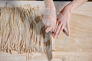 Unrecognizable woman slicing noodles