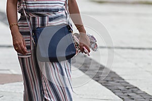 Unrecognizable woman in the street with her mobile phone in hand