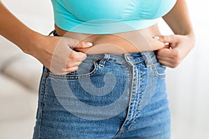 Unrecognizable Woman Touching Drooping Stomach After Weight Gain At Home