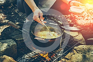 Unrecognizable woman tourist cooking on campfire in forest. Concept Tourism Camping Survival Wildlife