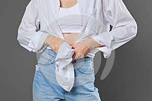 Unrecognizable woman tying a shirt in a knot