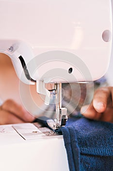 unrecognizable woman using a sewing machine to manufacture clothing. Employment issues