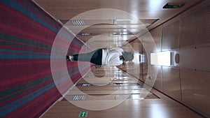 an unrecognizable woman walks away along the long corridor of the ship