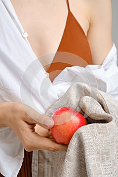 Unrecognizable woman wiping an apple with a towel