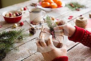 Unrecognizable woman wrapping and decorating Christmas present