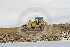 Unrecognizable worker driving industrial bulldozer heavy-duty machinery