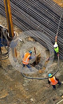 Unrecognizable workers with hydraulic hammer drilling machine at