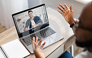 Unrecognizable young african american guy teacher explain online lesson to class, with student at computer screen