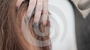 Unrecognizable young hairdresser drying her clients hair