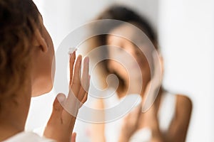 Unrecognizable Young Lady Applying Face Cream In Bathroom