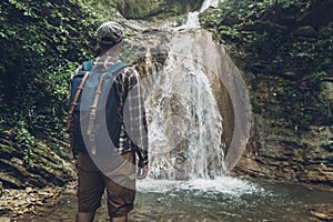 Unrecognizable Young Man Has Reached Destination And Enjoying View Of Waterfall. Journey Hiking Adventure Concept