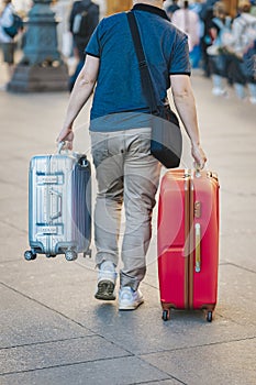 Unrecognizable young man traveling with suitcases, travel and tourism concept