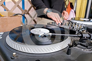 Unrecognizable young white DJ at the music desk during a DJ set on the terrace of a trendy youth bar